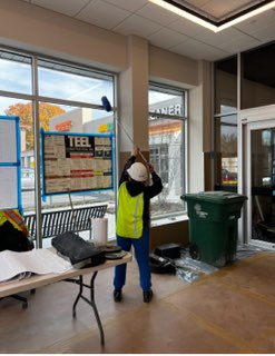 Crew member cleaning storefront glass