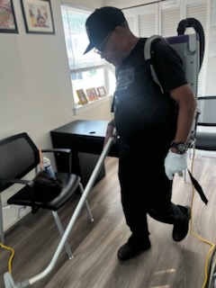 Crew member vacuuming an office floor