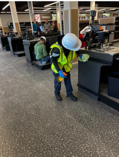 Crew member cleaning a retail checkout area